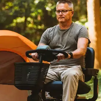 An older man riding a mobility scooter outdoors